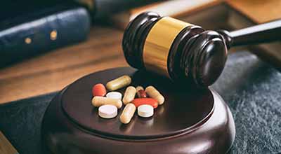 Judge gavel and drugs on a wooden desk