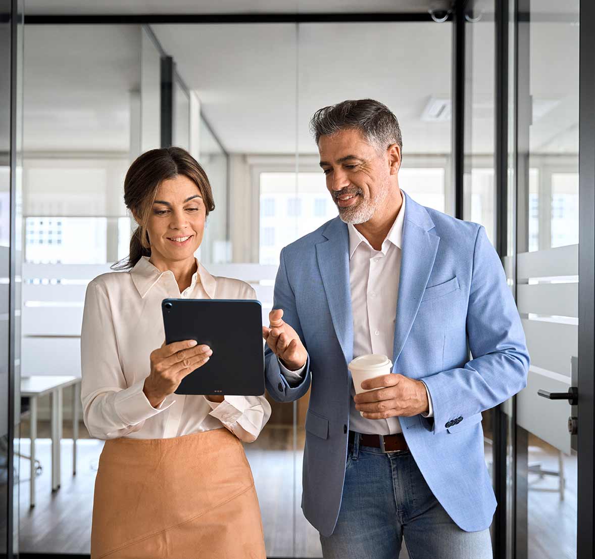 Two busy business man and woman executives team using tablet in office.